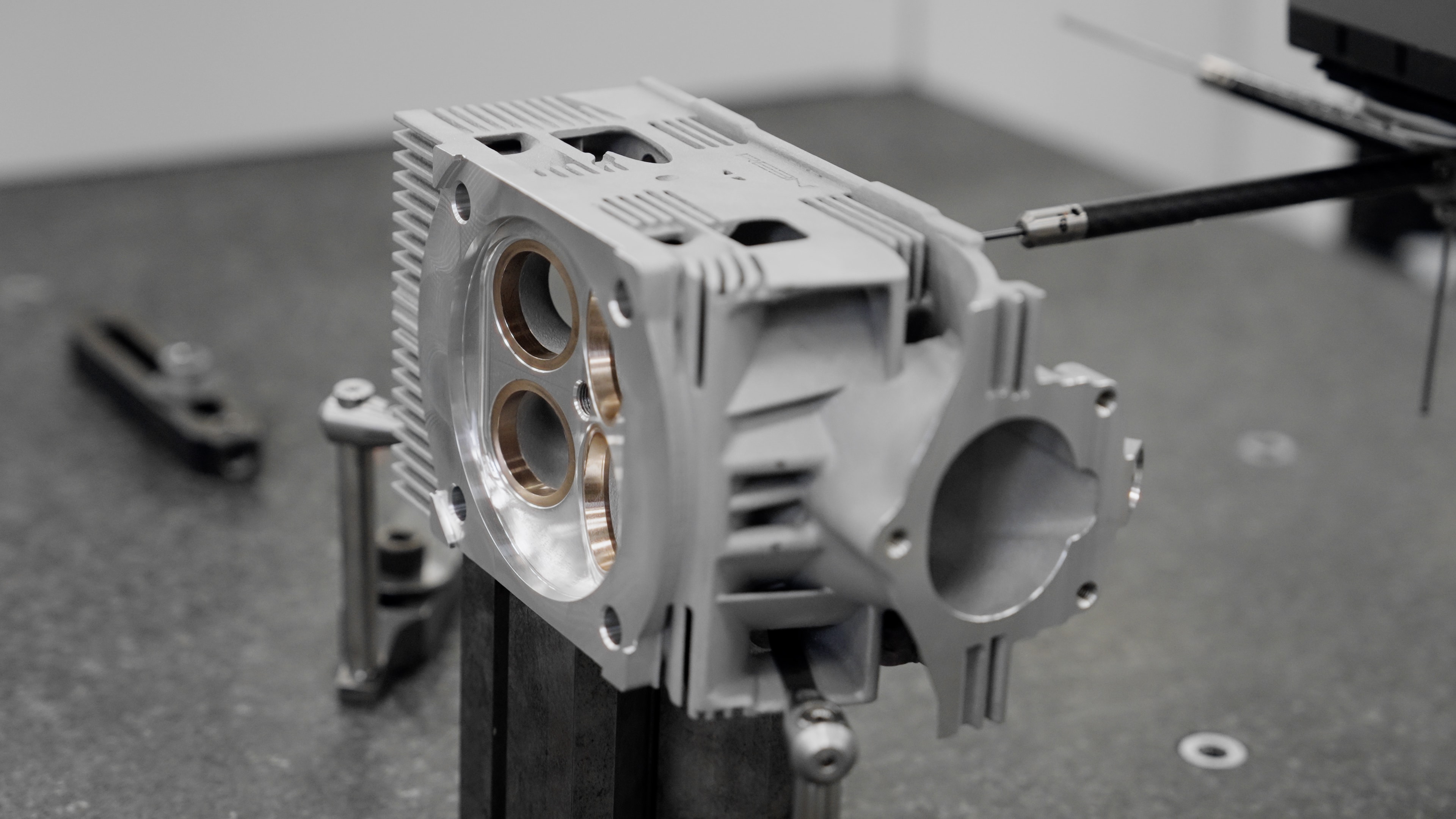 Partners inspecting a finished REEN cylinder head